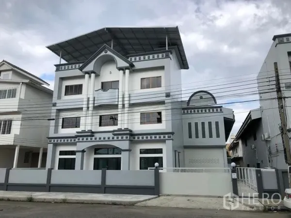 Factory for rent in Pak Kret, Nonthaburi - Three-storey factory and office exterior with gated fence and large roof canopy.