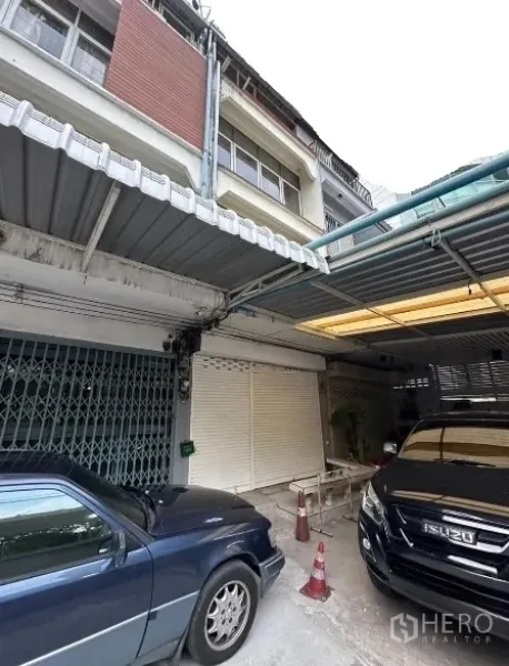 Shophouse for rent in Watthana, Bangkok - Multi-storey shophouse facade with wide rolling shutter and covered parking in Ekkamai, Bangkok.
