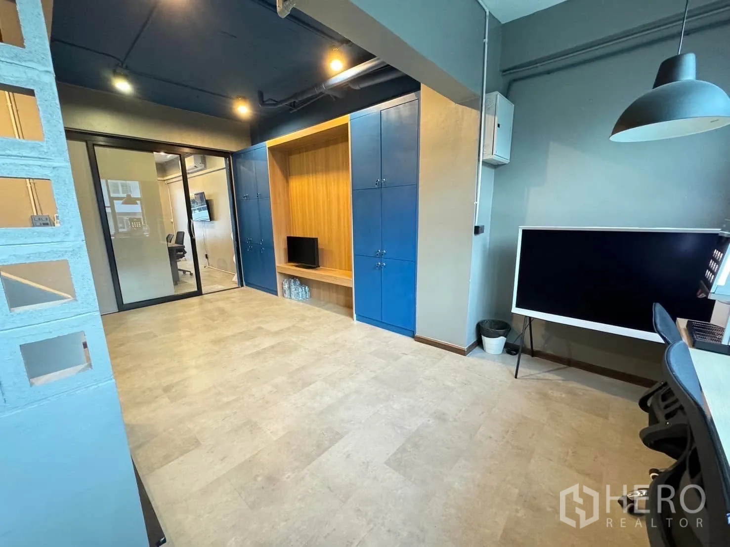 โฮมออฟฟิศ for rent in Watthana, Bangkok - โซนทำงานแบบเปิดพร้อมตู้บิวท์อินสีน้ำเงินและประตูกระจกบานเลื่อน