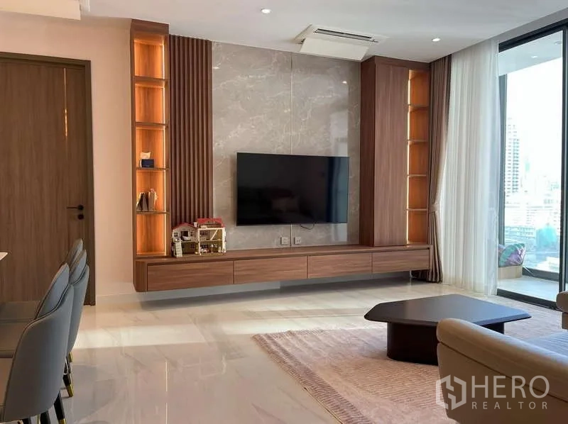 Condominium for rent or sale in Sathon, Bangkok - Living area with marble feature wall, floating TV cabinet and built-in shelves.