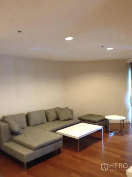 คอนโด ให้เช่าในHuai Khwang, Bangkok - ห้องนั่งเล่นกว้าง โซฟาเข้ามุมผ้าและโต๊ะกลางคู่ บนพื้นไม้