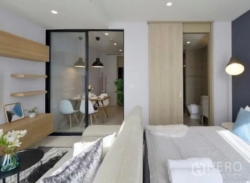 Condominium for rent in Pathum Wan, Bangkok - Open layout showing lounge, glass door to the dining room, and sliding door to the bathroom.