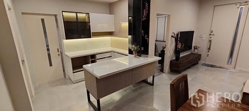 Detached House for rent in Prawet, Bangkok - Pantry-style kitchen with marble island, built-in cabinets, and soft under-cabinet lighting.