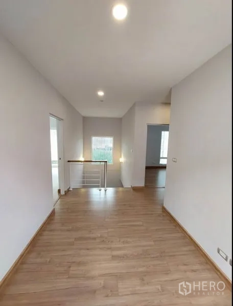 Detached House for sale in Bang Yai, Nonthaburi - Upstairs landing with wood floors and white stair railing