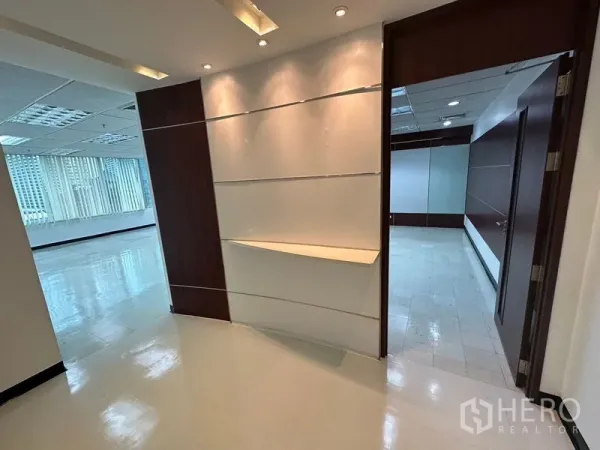 Office Space for rent in Chatuchak, Bangkok - Reception nook with built-in display shelf, spotlights and wood trim leading to offices.