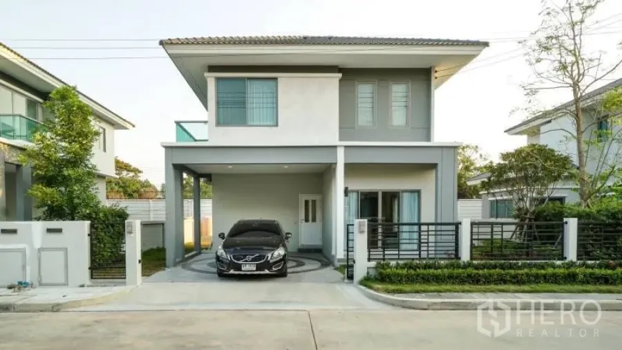 独立式住宅 出租或出售在Lat Krabang, Bangkok - 现代两层独栋住宅，带顶车位、围栏前院与车道，社区环境安静。