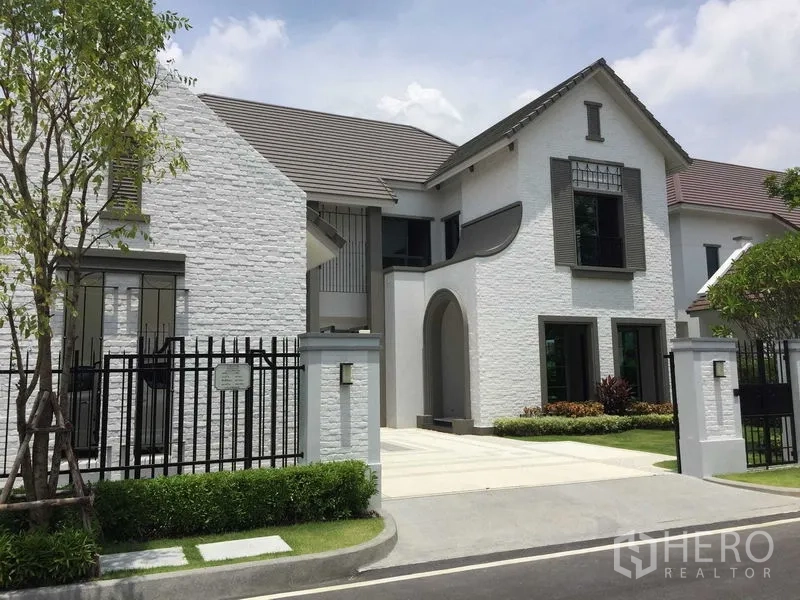 独立式住宅 出售在Mueang Samut Prakan, Samut Prakan - 白砖外立面的独栋住宅，带车道大门与前庭绿化