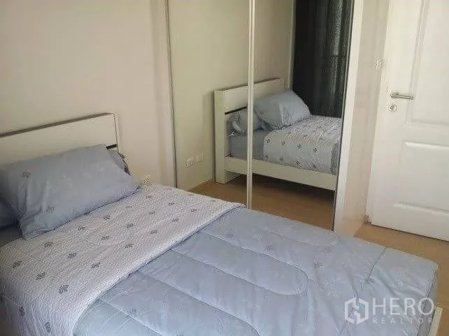 Condominium for rent in Bangkok - Cozy bedroom with single bed, mirrored wardrobe and soft blue bedding.