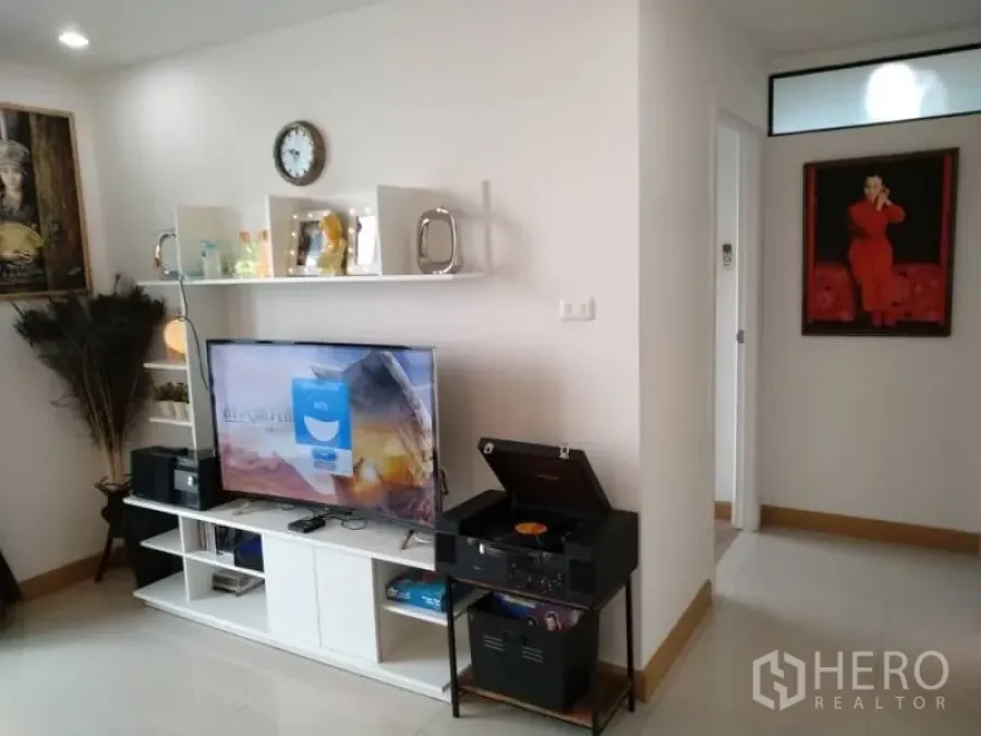 公寓 出租在Watthana, Bangkok - 明亮客厅，电视柜、壁挂置物架与通往卧室的走廊