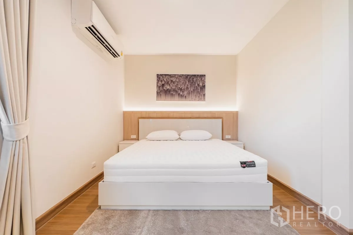 Detached House for rent or sale in Prawet, Bangkok - Minimal bedroom with white bed, soft feature lighting and wall art