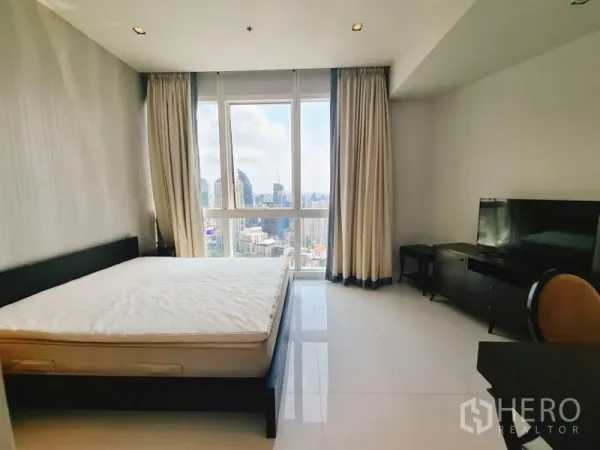 Condominium for rent in Khlong Toei, Bangkok - Master bedroom facing tall windows with curtains and panoramic city views.