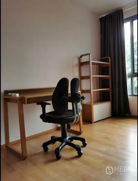 Condominium for rent in Khlong Toei, Bangkok - Work-from-home corner with desk, shelving, and a floor-to-ceiling window.