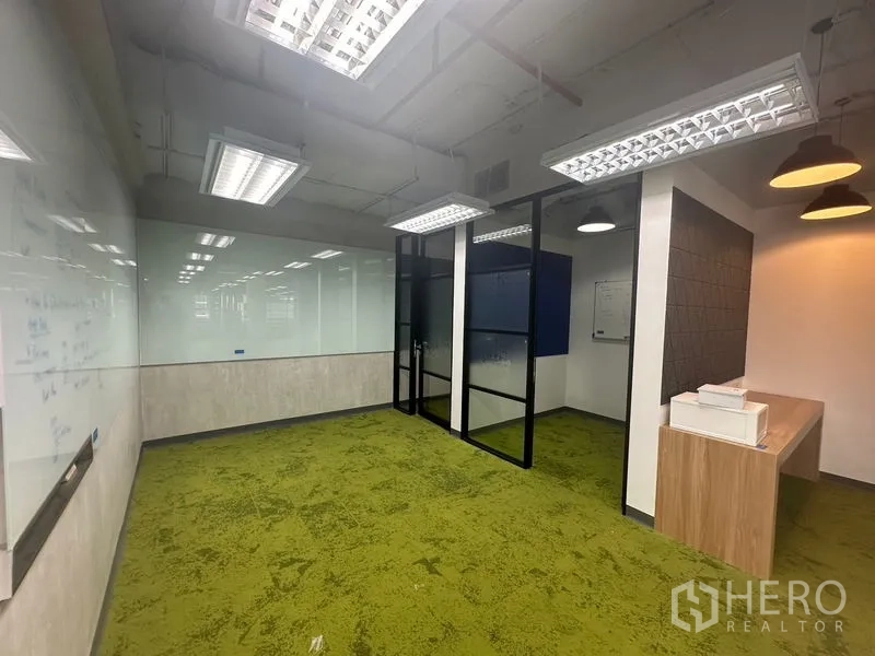 办公空间 出租在Bang Rak, Bangkok - 绿色地毯会议室，整面白板与现代灯具。