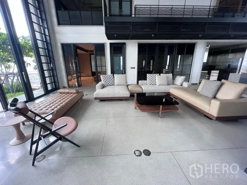 Condominium for rent in Sathon, Bangkok - Open-plan lounge with contemporary sofas facing a garden-side terrace.