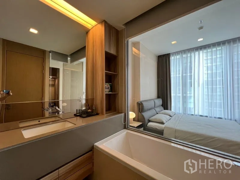 公寓 出租在Watthana, Bangkok - 现代卫浴，带洗手台收纳与靠窗浴缸，与卧室相连。