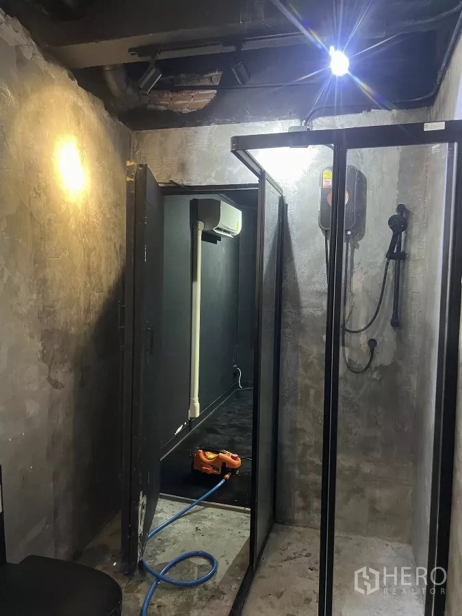 带办公室的家 出租在Wang Thonglang, Bangkok - 工业风浴室，混凝土墙体，玻璃淋浴间与壁挂式热水器。