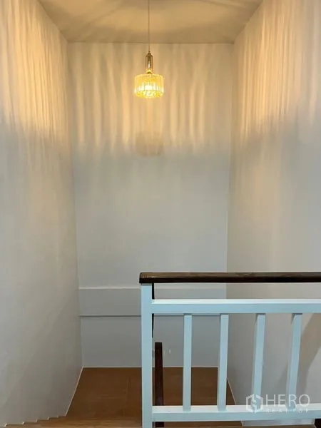 Townhouse for rent in Din Daeng, Bangkok - Stair landing with a modern pendant light and clean white walls.