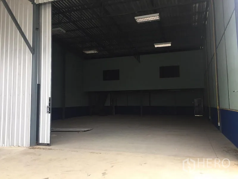 货栈 出租在Lat Krabang, Bangkok - 仓库宽阔入口，金属门半开，前方有装卸空间