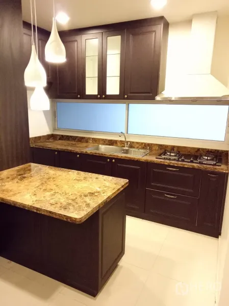Townhouse for rent in Suan Luang, Bangkok - Modern kitchen with marble island, gas hob, range hood and dark wood cabinetry