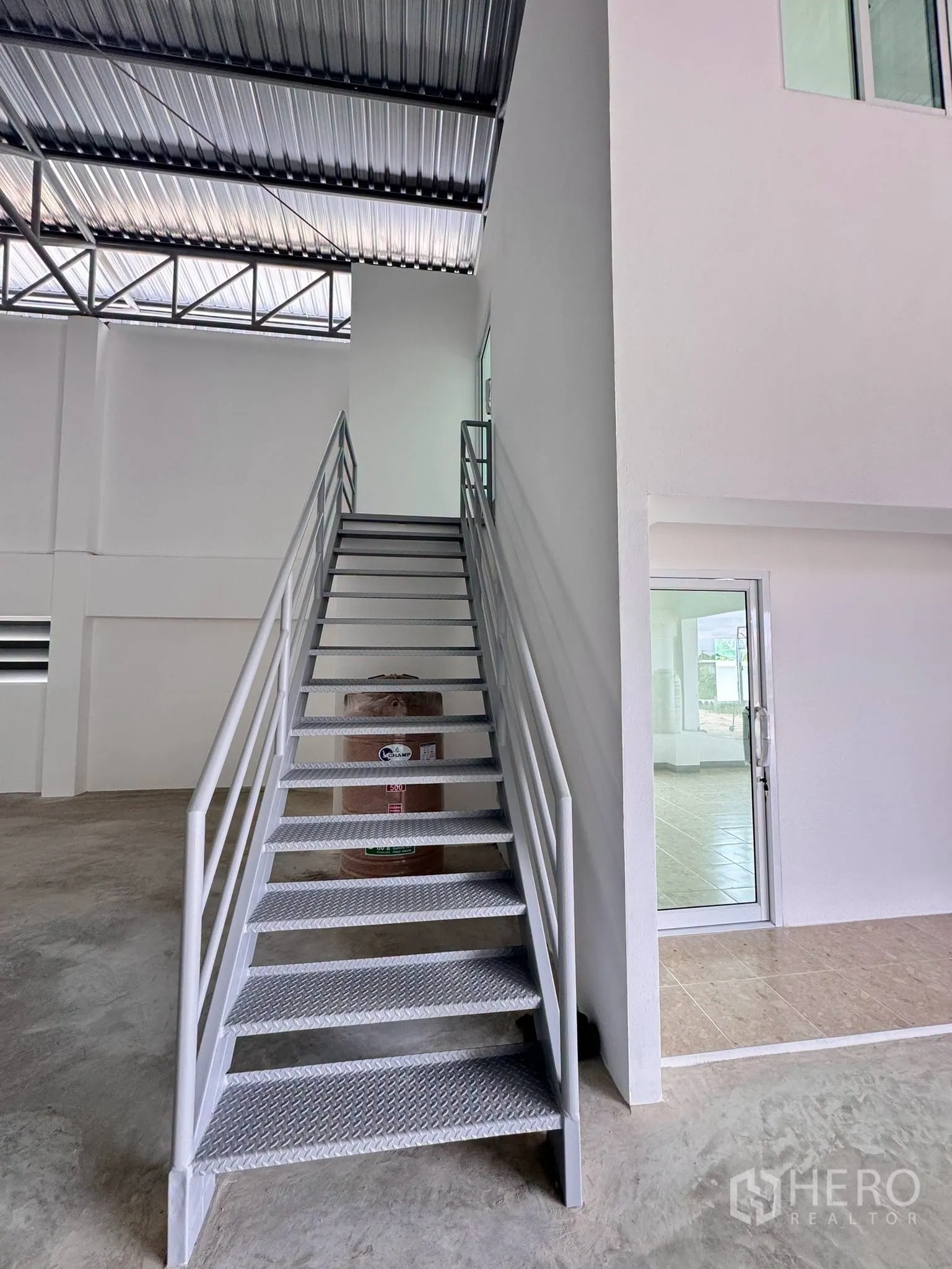Warehouse for rent in Bang Bo, Samut Prakan - Metal staircase leading to the mezzanine office beside a glass door entrance.