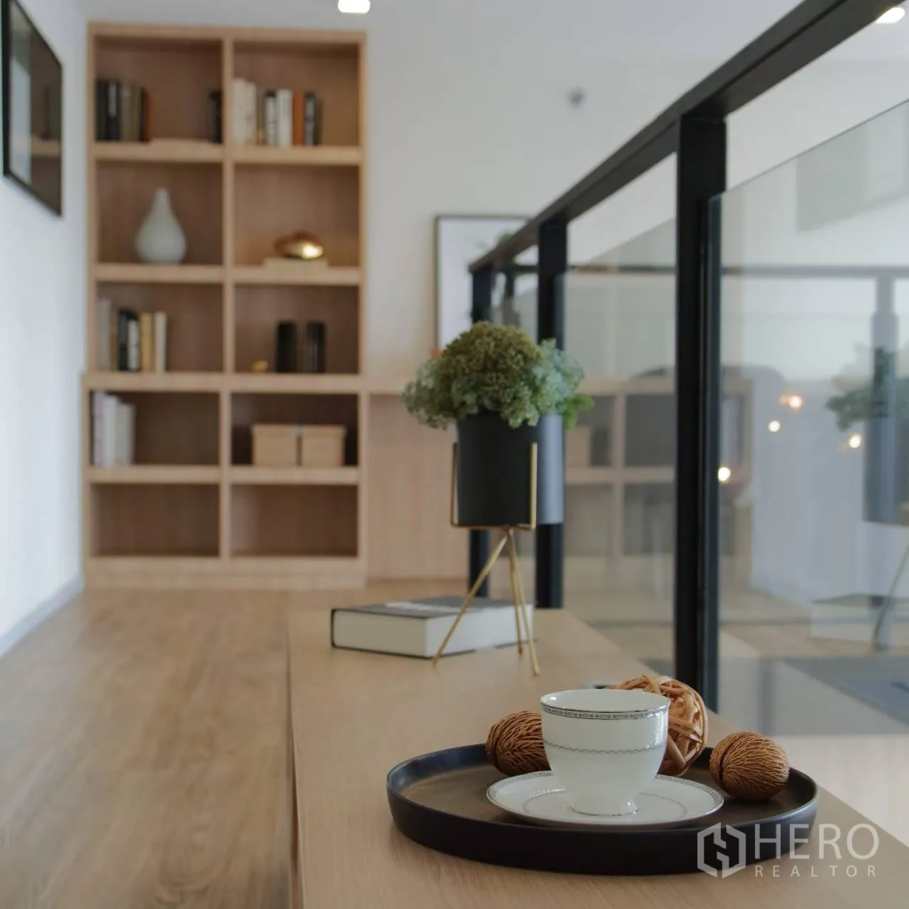 Condominium for rent or sale in Khlong Toei, Bangkok - Loft walkway with shelving, glass balustrade, and decorative tray on a bench.