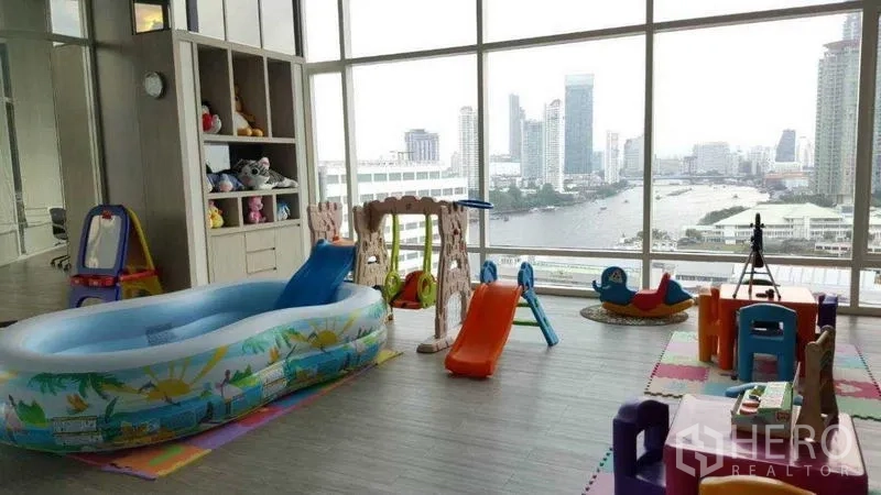 Condominium for rent in Bang Kho Laem, Bangkok - Indoor kids’ playroom with toys and slides facing large windows.