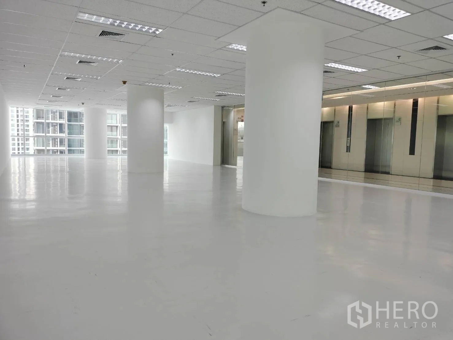 零售空间 for rent in Sathon, Bangkok - 明亮楼层配亮面地坪与圆柱，邻近镜面电梯大堂。