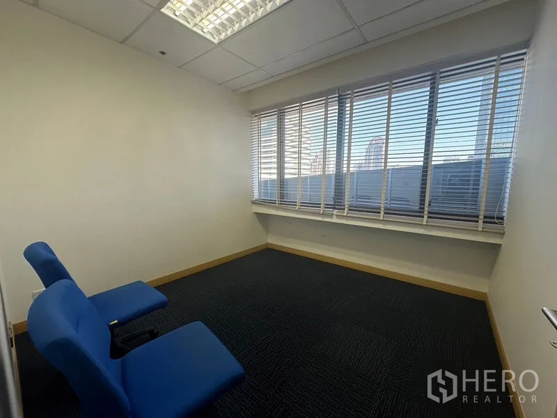 Office Space for rent in Bang Na, Bangkok - Bright office corner with two blue chairs and a wide window with city views.