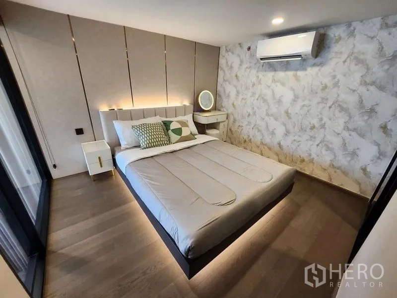 Condominium for rent - Primary bedroom with feature headboard, ambient lighting, and air conditioning.