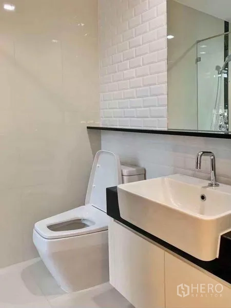 公寓 出售在Ratchathewi, Bangkok - 现代浴室，白色瓷砖、方形台盆与玻璃淋浴间。