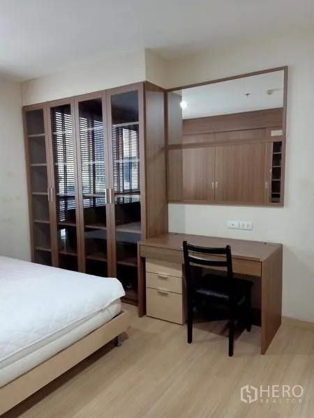 公寓 出租在Bang Rak, Bangkok - 卧室更衣区，玻璃门柜与内置梳妆台及镜子。
