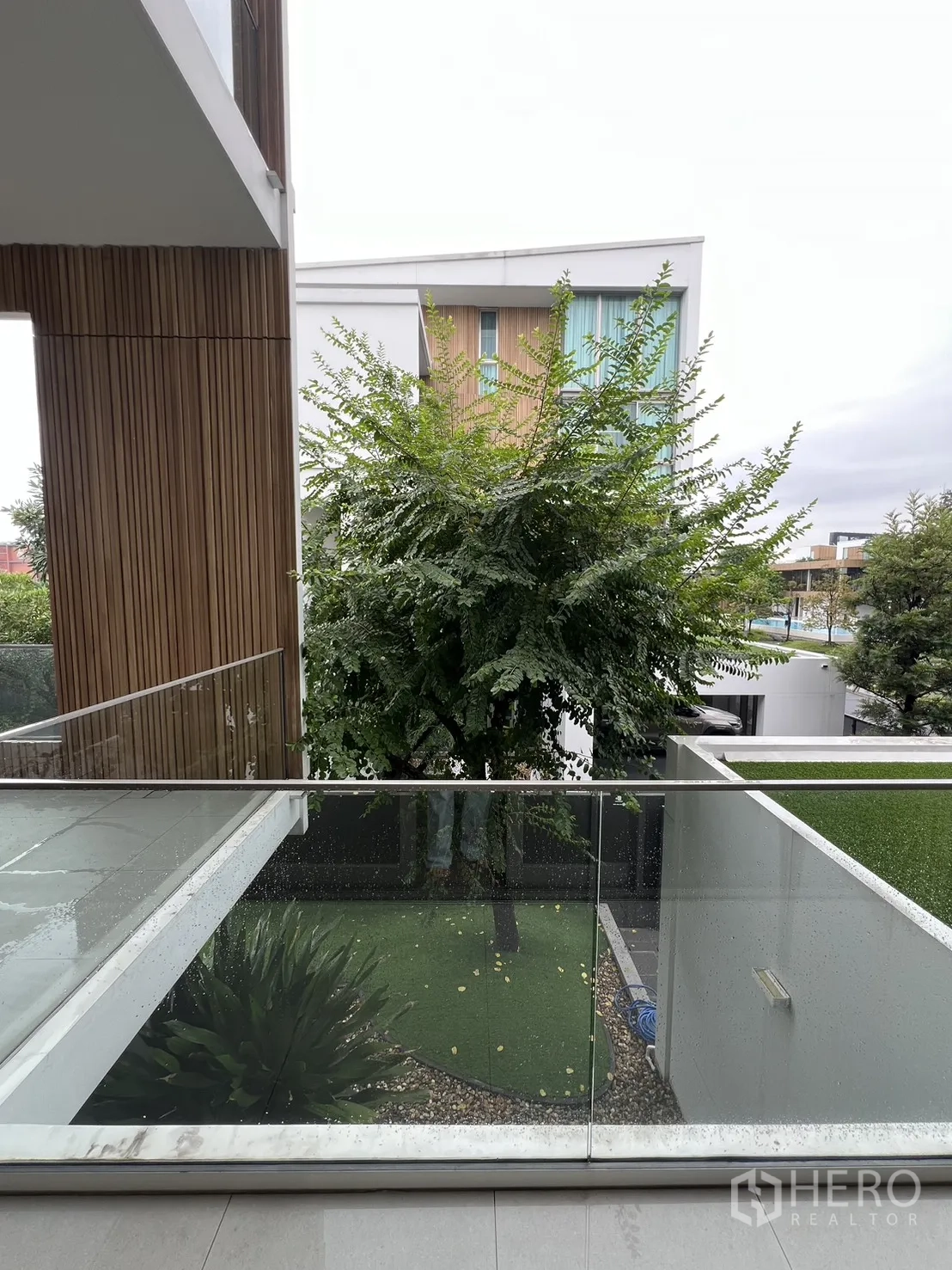 Detached House for rent in Saphan Sung, Bangkok - Side balcony view of a tree-lined neighborhood and garden below.