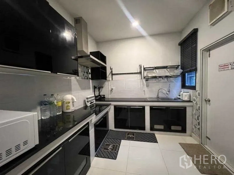 独立式住宅 出租在Mueang Nonthaburi, Nonthaburi - 全配厨房，亮面柜体与家电、油烟机齐备。