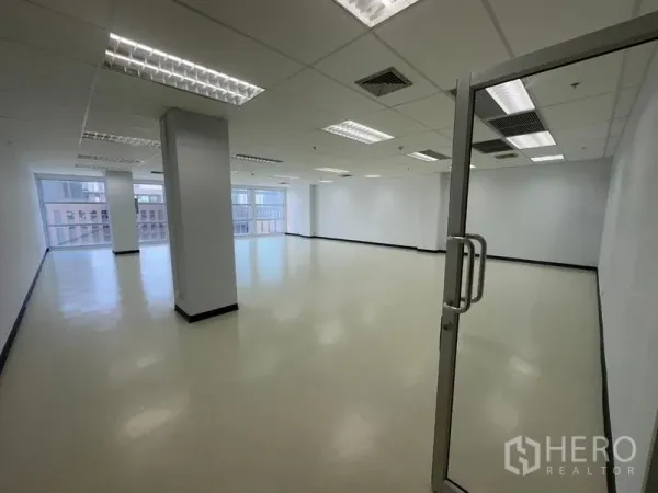 办公空间 出租在Bang Na, Bangkok - 玻璃入户门通向现代办公室，带立柱与空调出风口。