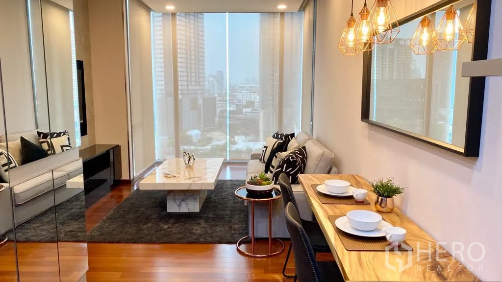 Condominium for sale in Khlong Toei, Bangkok - Bright living and dining area with pendant lights, marble coffee table and skyline views through floor‑to‑ceiling windows.