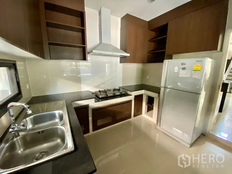 独立式住宅 出租在Prawet, Bangkok - 配备燃气灶、排风罩、柜体、双槽水盆与冰箱的厨房