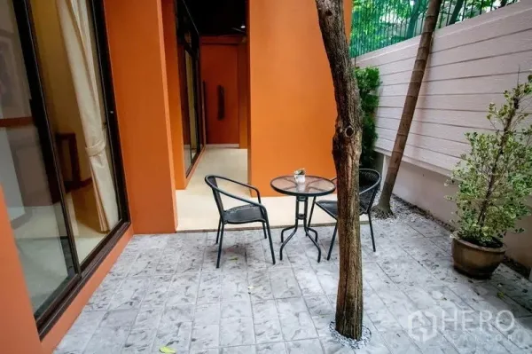 ทาวน์เฮาส์ ให้เช่าในWatthana, Bangkok - ลานนั่งเล่นส่วนตัวพร้อมชุดโต๊ะกลม เก้าอี้ และผนังสีส้ม