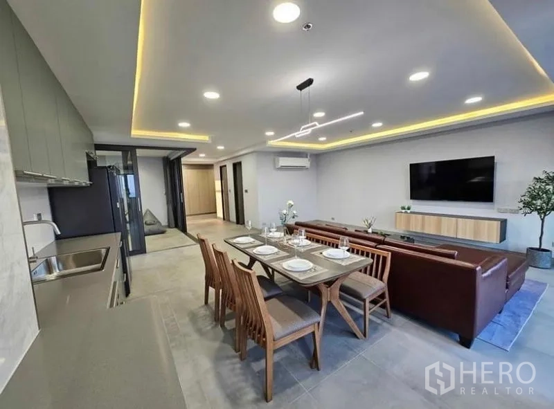 Condominium for rent or sale - Dining area beside full-length kitchen cabinets and LED ceiling lights.