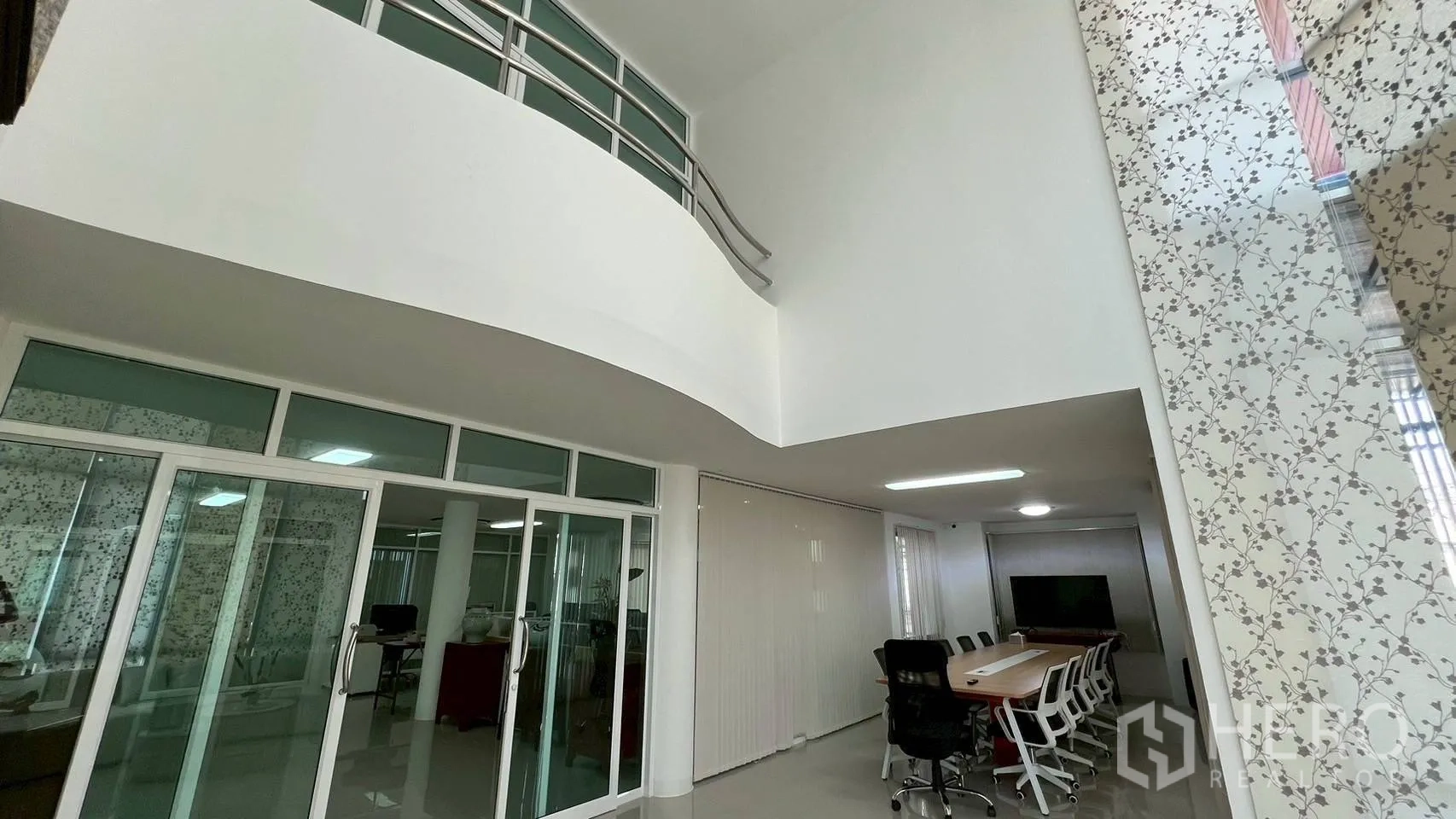 家庭办公室 for rent in Wang Thonglang, Bangkok - 挑高中庭与夹层栏杆，上方俯瞰玻璃墙会议室。