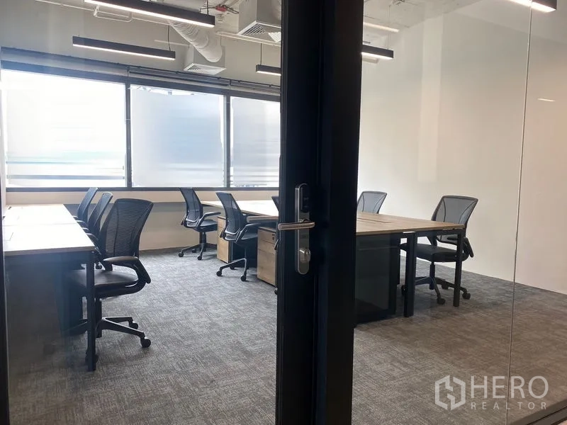办公室 for rent in Bang Rak, Bangkok - 透过玻璃门可见明亮办公室，设多组办公桌与磨砂窗。