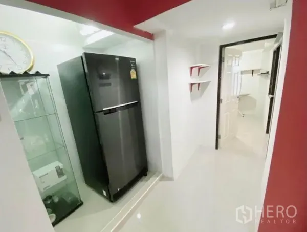 联排别墅 出租在Wang Thonglang, Bangkok - 走廊壁龛放置双开门冰箱与玻璃展示柜。