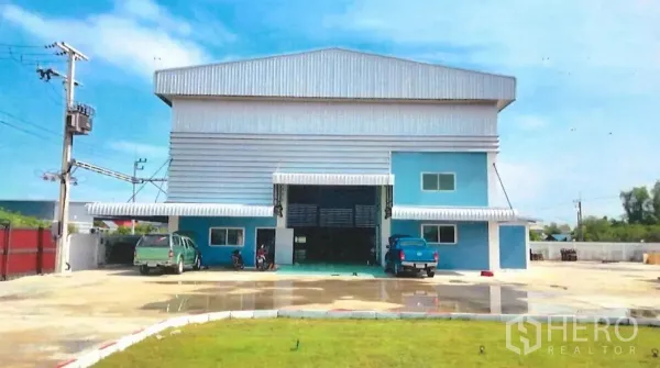 Factory for sale in Lat Lum Kaeo, Pathum Thani - Front view of a blue and grey steel-clad factory with large roller door and wide parking yard.