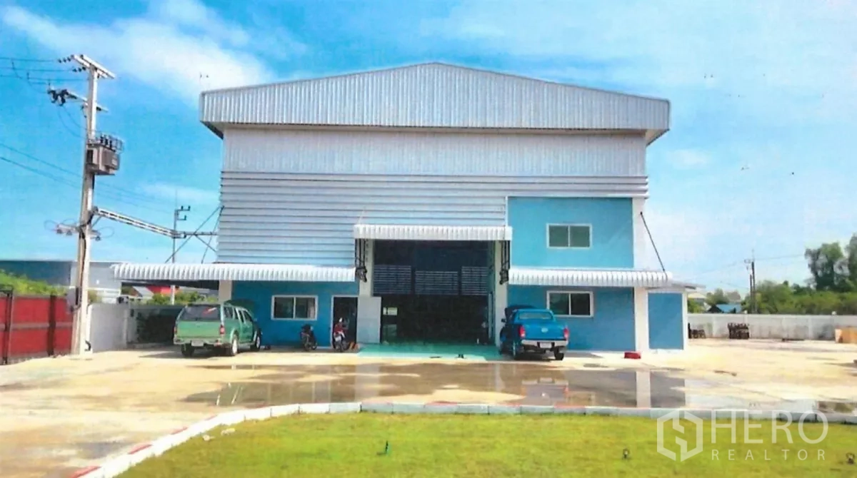 Factory for sale in Lat Lum Kaeo, Pathum Thani - Front view of a blue and grey steel-clad factory with large roller door and wide parking yard.