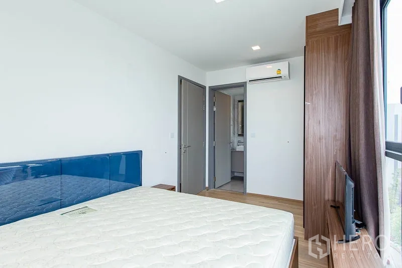 公寓 出租在Watthana, Bangkok - 卧室内置衣柜、空调，设有通往卫浴的门，布局实用。