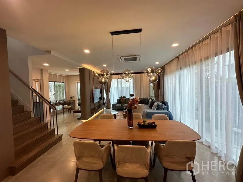 Detached House for rent in Samut Prakan - Open-plan dining and living area with statement pendant lighting.