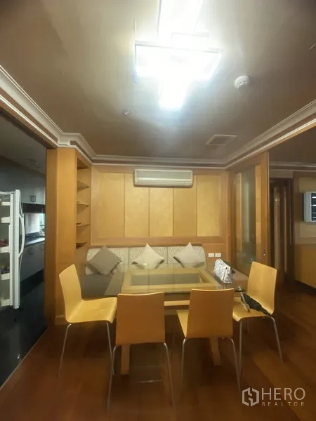 Condominium for rent in Pathum Wan, Bangkok - Cozy dining nook with built-in bench, shelving, and air-conditioning beside the entrance to the kitchen.