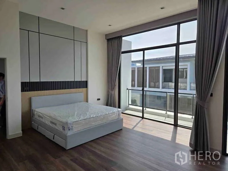 Detached House for rent in Bang Phli, Samut Prakan - Primary bedroom with floor-to-ceiling glass and access to a balcony.