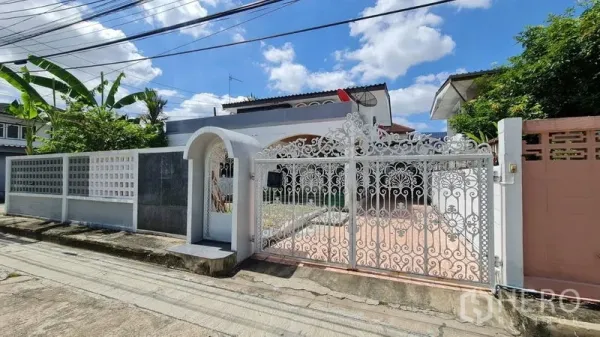 บ้าน ให้เช่าในLat Phrao, Bangkok - ประตูรั้วเหล็กดัดลายสีขาวและกำแพงหน้าบ้านในซอยเงียบสงบ