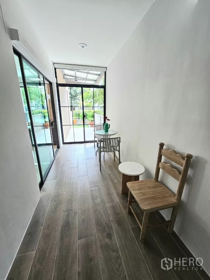 Townhouse for rent in Saphan Sung, Bangkok - Enclosed corridor with wood-look flooring and small seating by sliding doors.