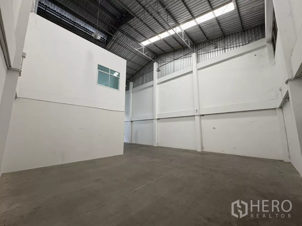 Factory for rent in Phra Samut Chedi, Samut Prakan - High-clear factory floor with white walls and metal truss ceiling.